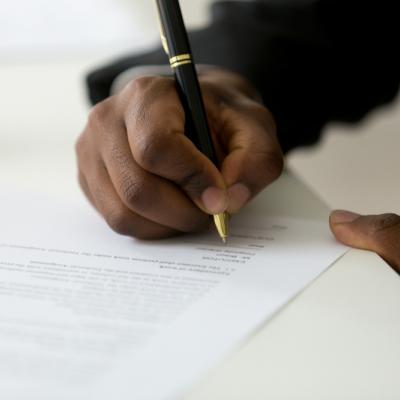 Image of hand signing a letter